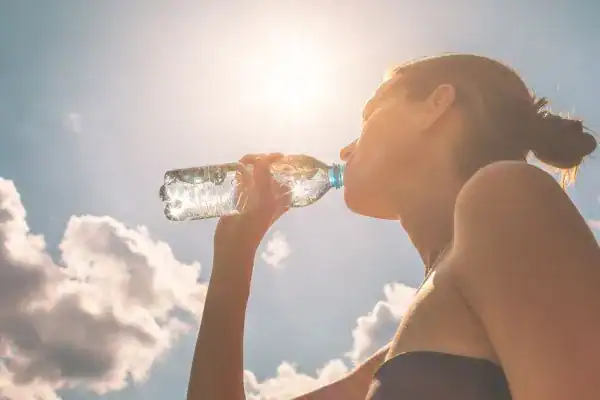 Hydration: The Secret Ingredient for a Toned Stomach and Enhanced Fitness 3 Image of woman drinking water to hydrate Beaconsfield after run.
